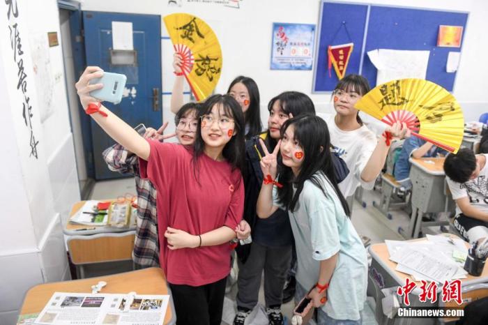 资料图:6月6日,2021年高考前夕,湖南长沙同升湖实验学校高三年级,考生们在教室内合影。 杨华峰 摄