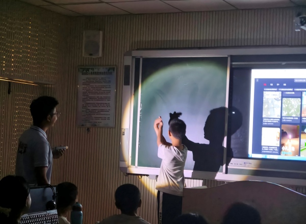 “物赴山河”团队带孩子们上趣味物理课堂,学生上台动手演示小孔成像光影实验(1).jpg